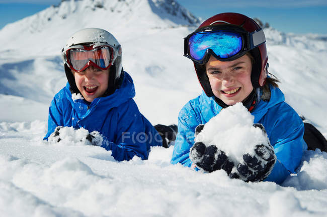 Niños haciendo bolas de nieve en la montaña - foto de stock