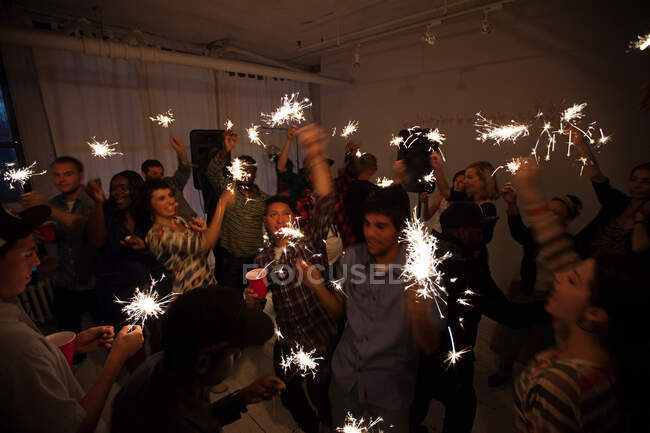 Люди танцуют на вечеринке с бенгальскими огнями — стоковое фото