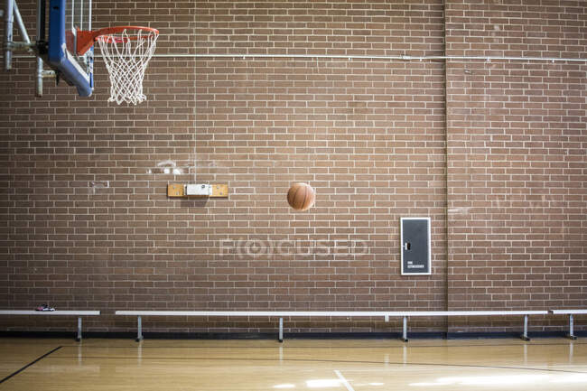 Baloncesto pelota en el aire en la cancha de baloncesto vacía - foto de stock