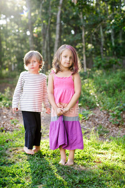 Retrato de menino e menina de pé no jardim — Fotografia de Stock