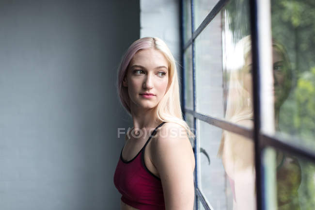 Side view of Dancer sitting on window sill while taking break in studio — Stock Photo