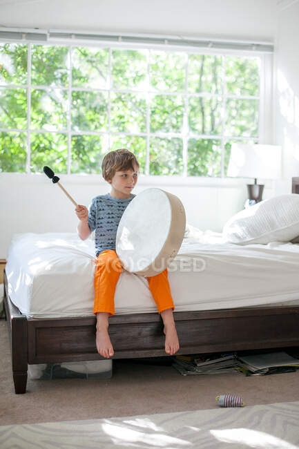 Junge trommelt auf Bett — Stockfoto