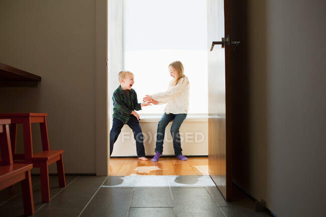 Brother and sister sitting on windowsill — Stock Photo