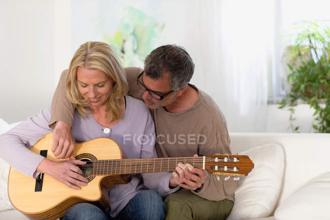 Hombre y mujer rasguñando guitarra - foto de stock