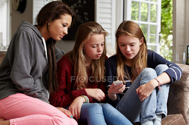Adolescentes olhando para um celular — Fotografia de Stock