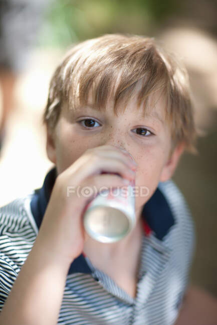 Мальчик пьет газировку на открытом воздухе — стоковое фото