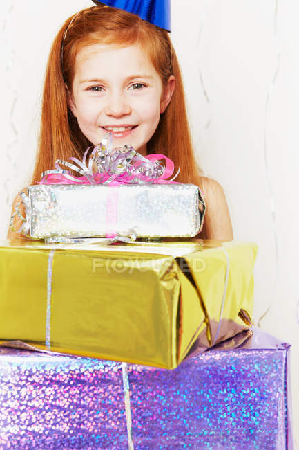 Girl with stack of birthday gifts — Stock Photo
