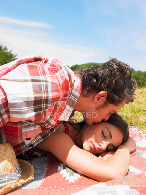 Casal em cobertor no campo — Fotografia de Stock