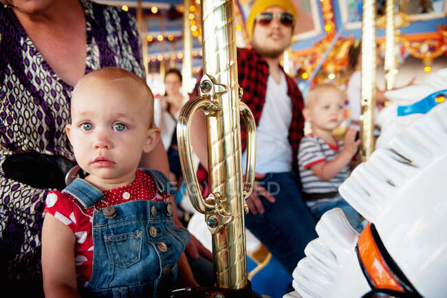 Famille avec deux enfants sur carrousel — Photo de stock