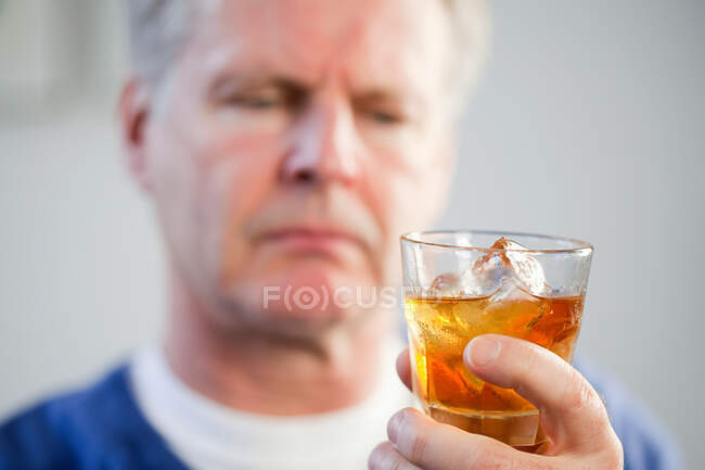 Hombre con vaso de whisky - foto de stock