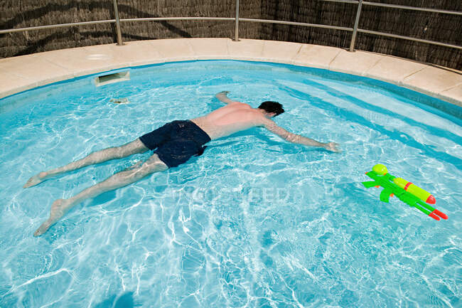 Man floating face down in swimming pool — Stock Photo