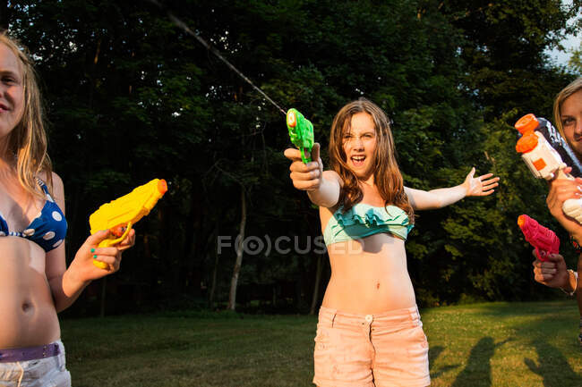 Girls having water fight with water pistols — Stock Photo