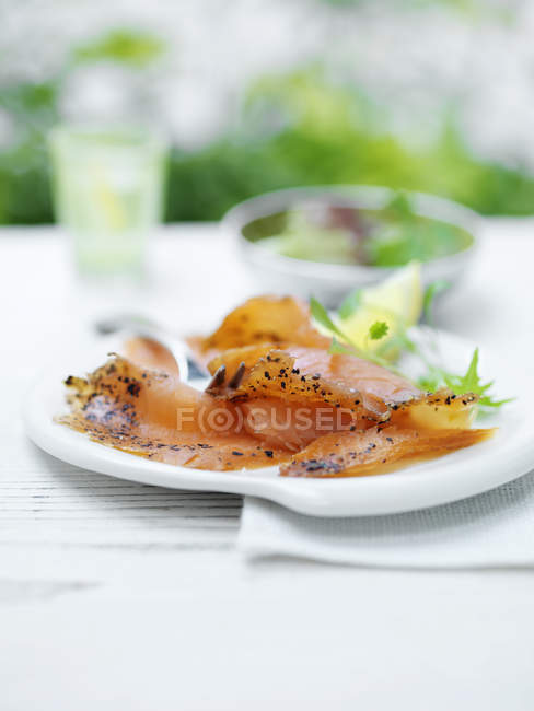 Delizioso salmone con limone a fette e foglie di insalata verde — Foto stock