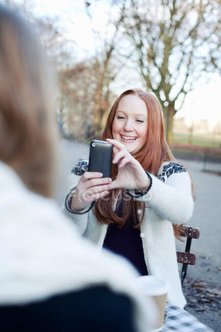 Femme prenant une photo de téléphone portable — Photo de stock
