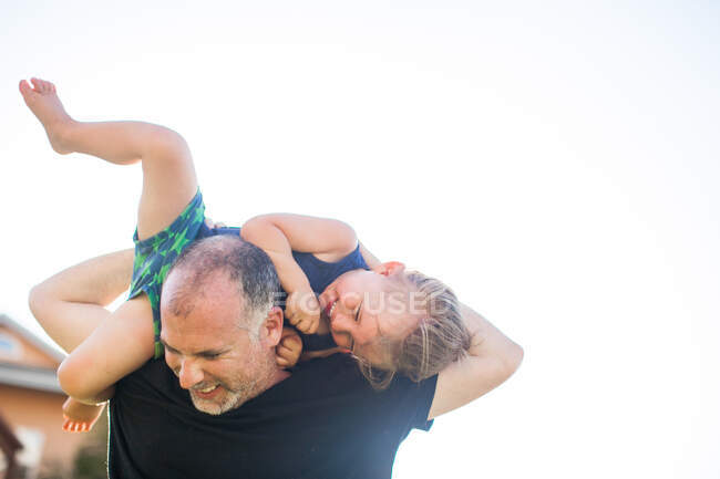 Vater und Sohn albern herum, draußen, Vater trägt Sohn über Schultern — Stockfoto