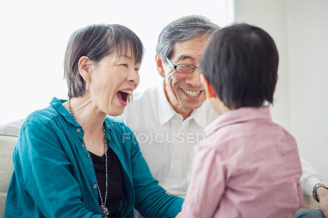 Бабусі і дідусі з онуком сміються — стокове фото