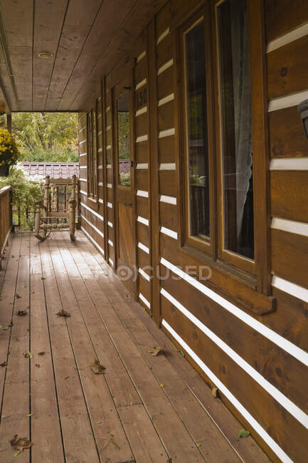 Veranda con sedia a dondolo sulla facciata della rustica casa in stile cottage canadese in autunno, Quebec, Canada. Questa immagine è proprietà rilasciata. CUPR0290 — Foto stock