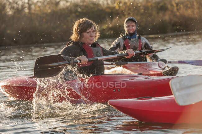 Femmes adultes milieu kayak sur le lac — Photo de stock