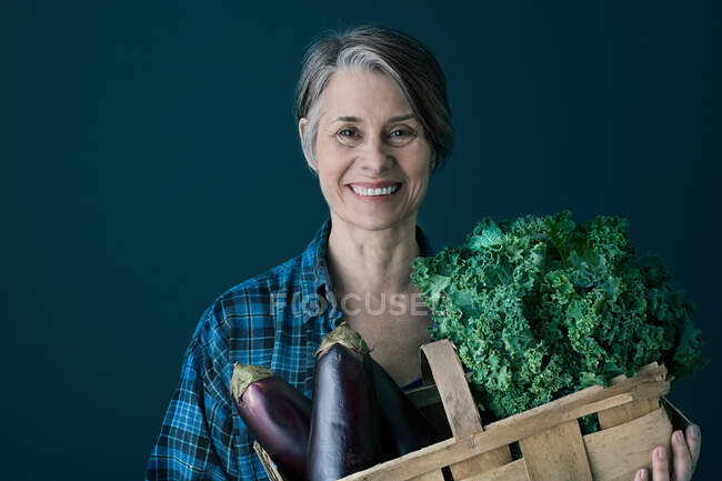 Woman with basket of vegetables — Stock Photo