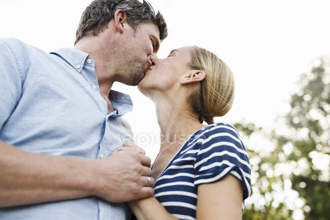 Романтична пара цілується в парку — стокове фото