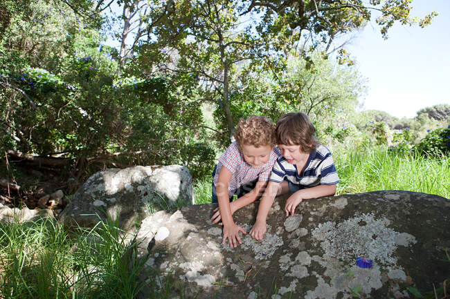 Двоє хлопчиків, спираючись на камінь — стокове фото