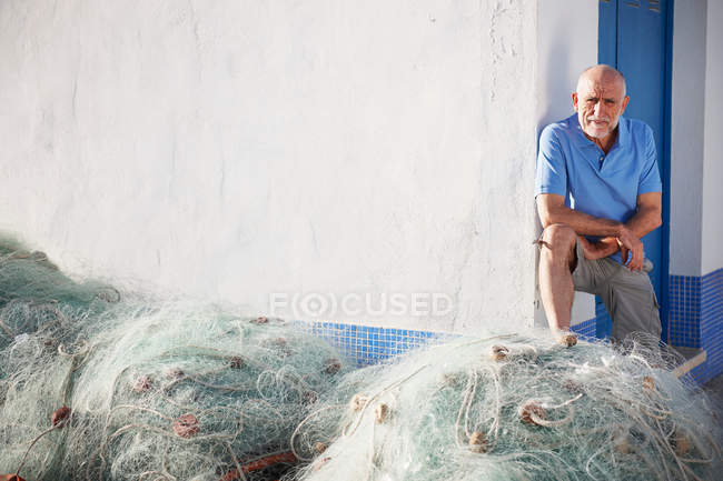 Рыбак с сетями возле здания — стоковое фото