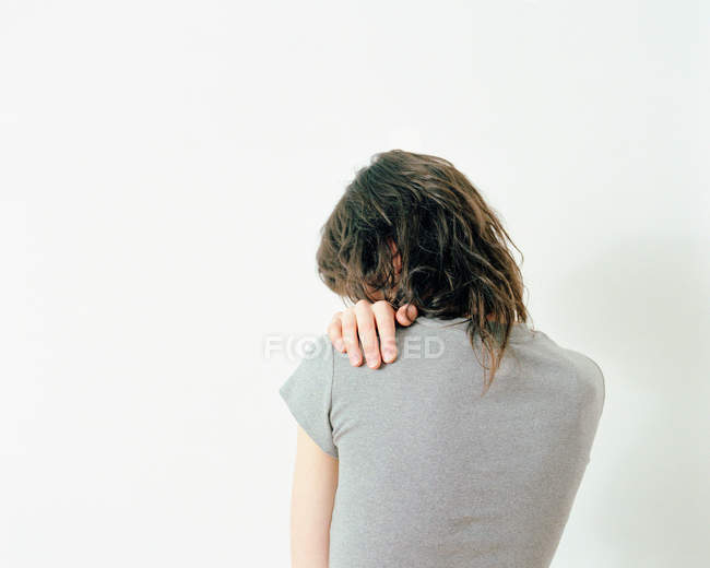 Visão traseira da mulher com a mão no ombro isolado no fundo branco — Fotografia de Stock