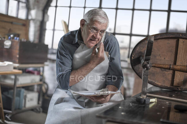 Kapstadt, Südafrika, älterer Handwerker in der Werkstatt auf Anruf — Stockfoto