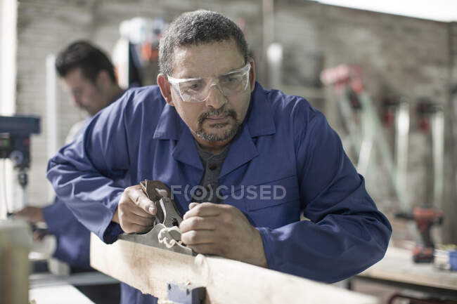 Cape Town, South Africa, machinist carving out wood with carving tool — Stock Photo