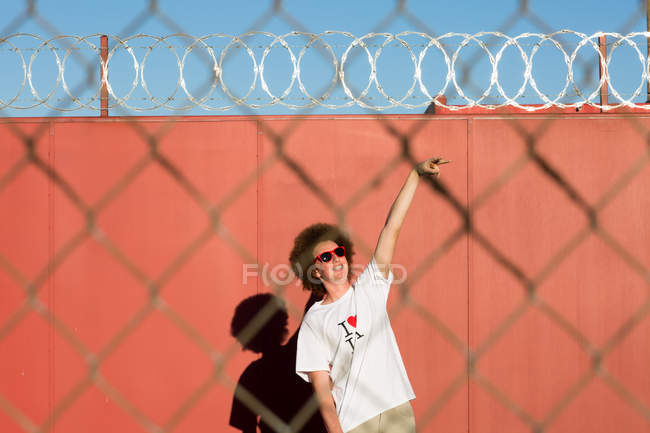 Мальчик-подросток с рыжими афроволосами, на улице, рука поднята — стоковое фото
