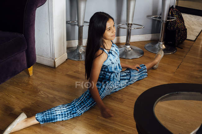 Дівчина робить розщеплення на підлозі вдома — стокове фото