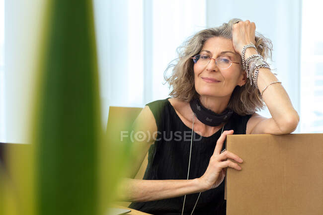 Retrato de la mujer de negocios senior relajándose en la silla de oficina - foto de stock