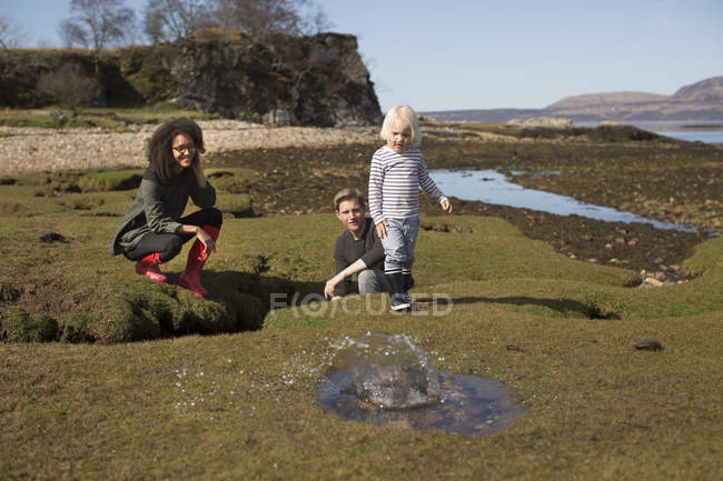 Rapaz a atirar pedras para a poça, Ilha de Skye, Hébridas, Escócia — Fotografia de Stock