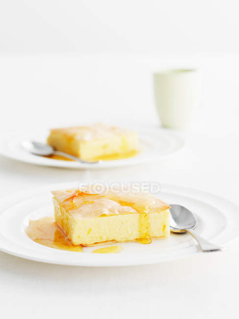 Platos de trozos de pastel de queso con salsa servida en la mesa - foto de stock