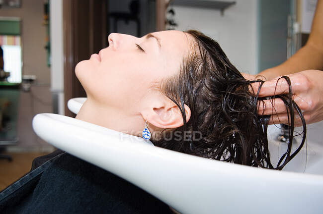 Mujer lavándose el pelo - foto de stock