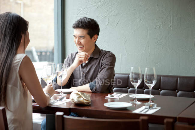 Pareja joven riendo en restaurante - foto de stock