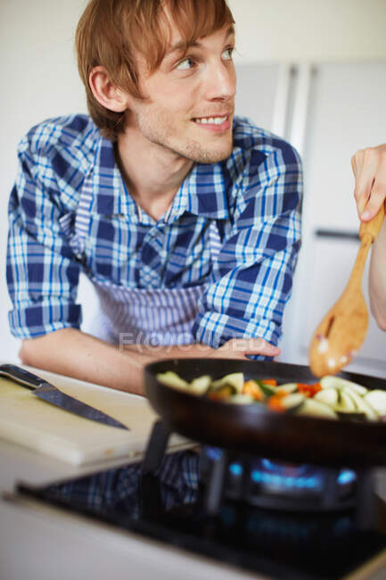Couple frying vegetables together — Stock Photo