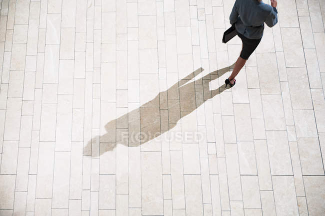 Empresaria corriendo sobre pavimento a la luz del sol — Stock Photo