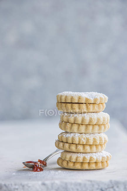 Stack of italian cookies and jam spoonful — Stock Photo