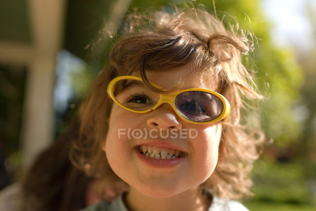 Young girl wearing broken sunglasses — Stock Photo