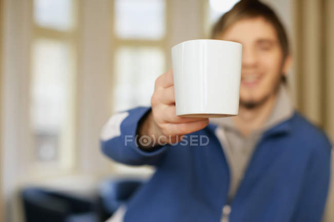 Человек предлагает чашку кофе — стоковое фото