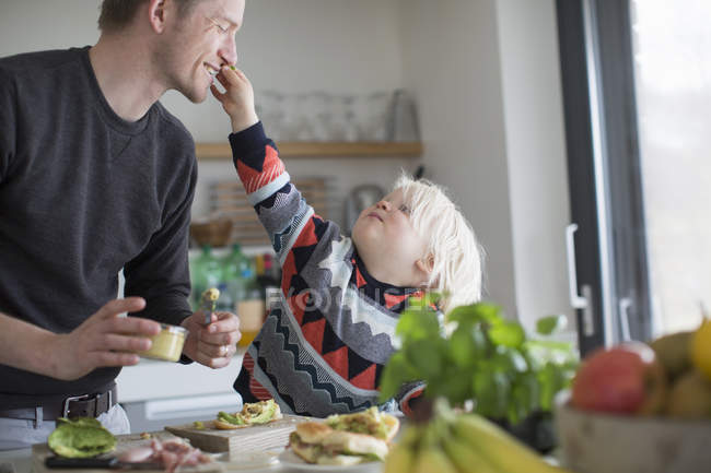 Junge berührt Vater in Küche zu Hause — Stockfoto