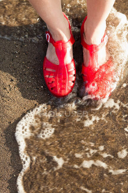 Donna che indossa sandali sulla spiaggia — Foto stock