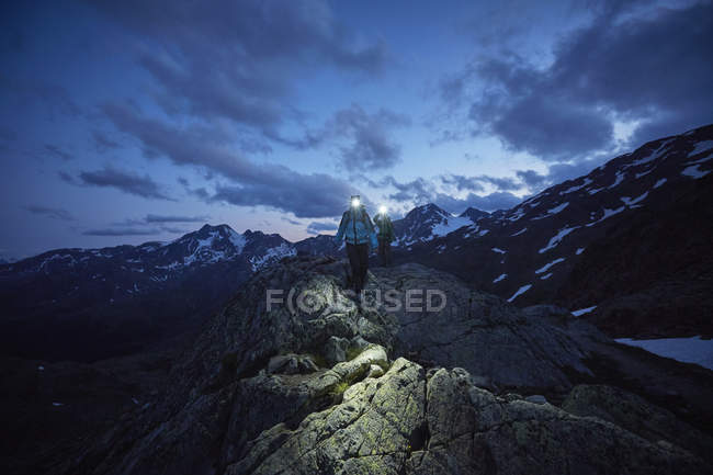 Young couple hiking at night wearing headlamps, Val Senales Glacier, Val Senales, South Tyrol, Italy — Stock Photo