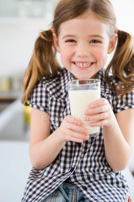 Girl smiling at camera holding glass — Stock Photo