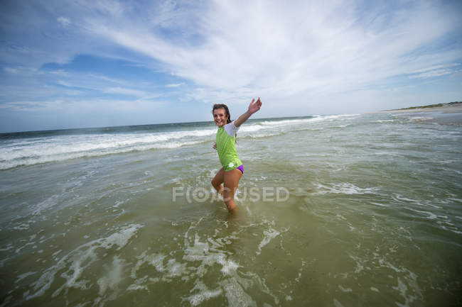Девушка, идущая по океанской волне — стоковое фото