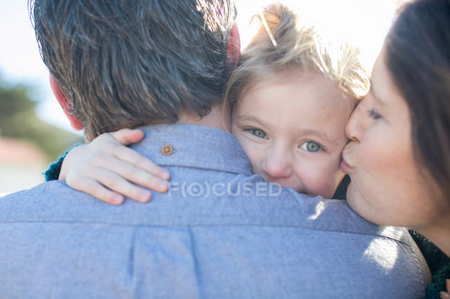 Close up of mid adult couple, mother kissing daughter's cheek — Stock Photo