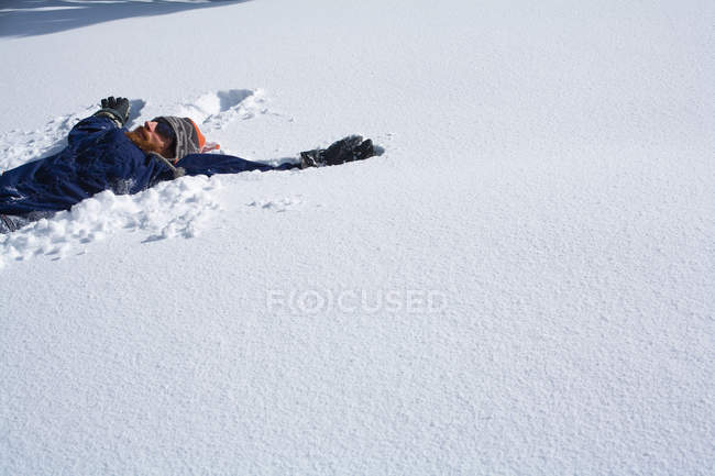 Snowboarder fare un angelo della neve — Foto stock