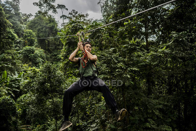 Homme sur fil zip dans la forêt, Ban Nongluang, province de Champassak, Paksong, Laos — Photo de stock