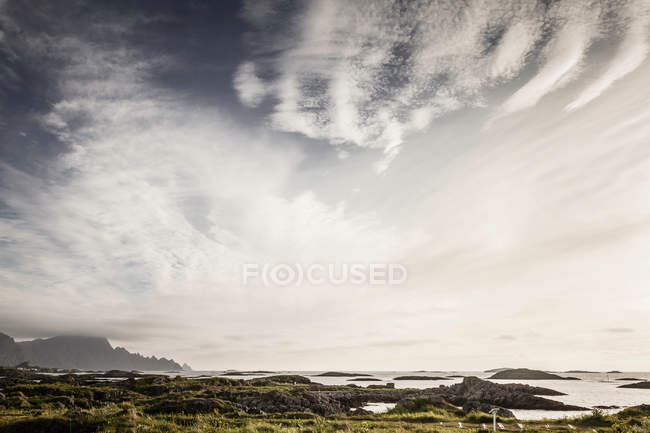 Clouds over rocky coastline — Stock Photo